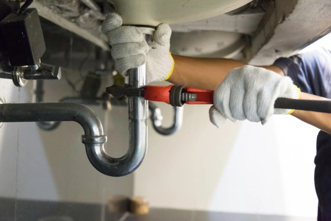 Plumbers in Katy, TX - 65a9454f7b522c7b3d24056d plumber fixing white sink pipe with adjustable wrench picture id1150199946